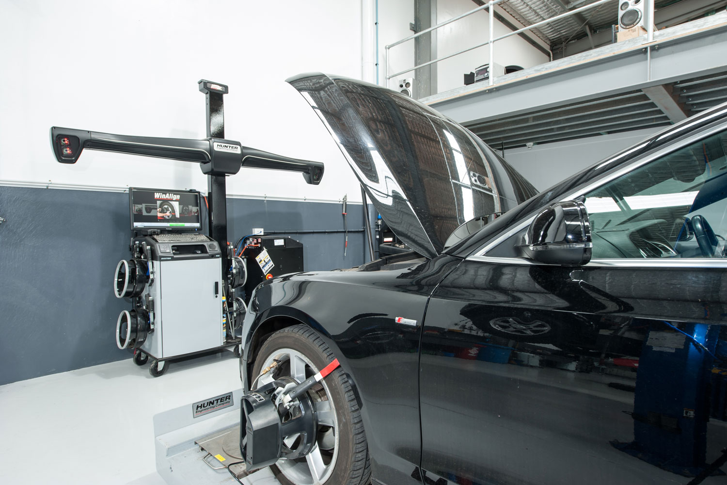 A black Audi car with open hood ready to be diagnose inside the workshop